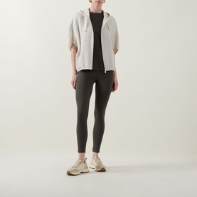 Model wearing Joseph Ribkoff Avocado top styled with cream zip hoodie and dark grey leggings