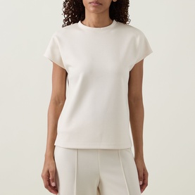 Model wearing Joseph Ribkoff Relaxed Scuba Top in birch, short sleeves, relaxed fit, styled with matching wide-leg trousers