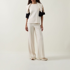 Model wearing Joseph Ribkoff Relaxed Scuba Top in Birch with black contrast sleeves, styled with matching wide-leg trousers.
