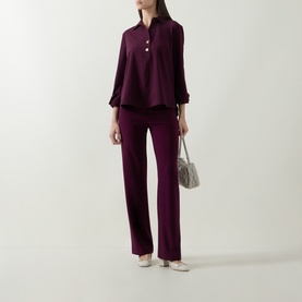 Model wearing Joseph Ribkoff elderberry top with matching wide-leg trousers, styled with cream flats and a grey shoulder bag.