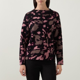 Model wearing Joseph Ribkoff Abstract Print Embellished Sweater in black and pink abstract print, boat neckline, long sleeves, straight hem