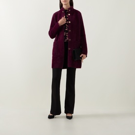 Model wearing Joseph Ribkoff Abstract Print Embellished Sweater in Black/Multi, styled with a burgundy coat, black trousers and heels.
