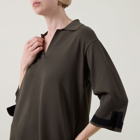 Model wearing Joseph Ribkoff Top in avocado and black with open collar and contrast black cuffs on three-quarter sleeves