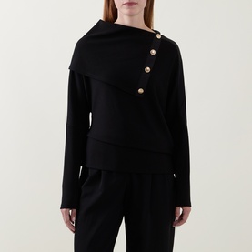 Model wearing Joseph Ribkoff black top with asymmetric fold-over collar and gold-tone button detail, styled with black trousers.