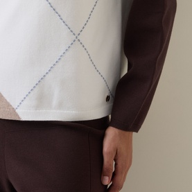 Model wearing Joseph Ribkoff Argyle Knitted Sweater in Mocha/Multi, close-up showing argyle pattern and long sleeves, styled with brown trousers.