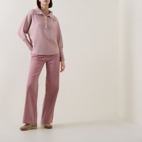 Model wearing Joseph Ribkoff Soft Blush Melange knit polo top with button placket, styled with matching wide-leg trousers and taupe slippers.