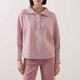 Model wearing Joseph Ribkoff Soft Blush Melange knit top with open collar, ribbed placket, and large buttons, styled with blush trousers.