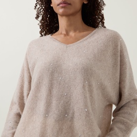 Model wearing Joseph Ribkoff oatmeal melange cashmere top with V-neck, batwing sleeves and scattered sequin embellishment