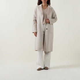 Model wearing Joseph Ribkoff Oatmeal Melange cashmere top, styled with a longline coat and wide-leg white trousers.