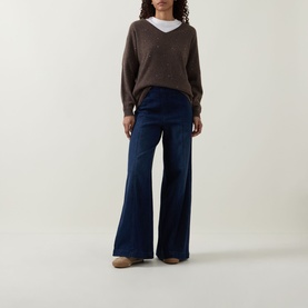 Model wearing Joseph Ribkoff Jewel Embellished Sweater in Dark Taupe Melange, V-neck cashmere knit, styled with wide-leg dark navy jeans.