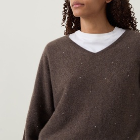 Model wearing Joseph Ribkoff Jewel Embellished Sweater in Dark Taupe Melange, V-neck cashmere knit with scattered jewel detail, styled over white tee