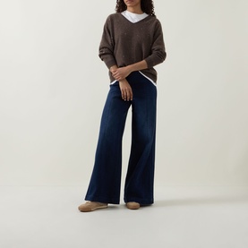 Model wearing Joseph Ribkoff Jewel Embellished Sweater in Dark Taupe Melange, V-neck cashmere knit, styled with wide-leg dark denim jeans.