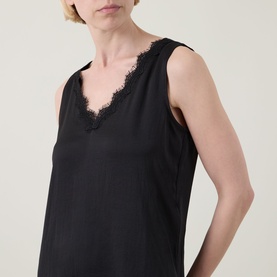 Model wearing Joseph Ribkoff black sleeveless top with V-neckline and delicate lace trim detail.