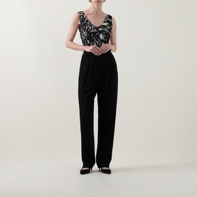 Model wearing Joseph Ribkoff grey/multi abstract print sleeveless top styled with black wide-leg trousers and black heels.