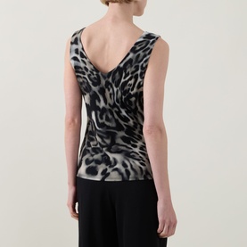 Model wearing Joseph Ribkoff grey multi leopard print sleeveless top with draped back neckline, styled with black trousers.