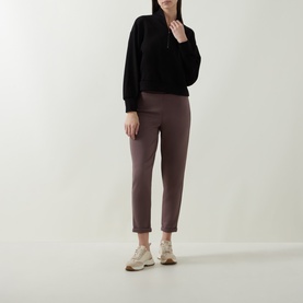 Model wearing Joseph Ribkoff Sporty Half-Zip Sweatshirt in black with shawl collar, styled with mauve tapered trousers and cream trainers.