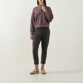 Model wearing Joseph Ribkoff Sporty Half-Zip Sweatshirt in Mink with half-zip neckline, styled with dark tapered trousers and beige trainers.