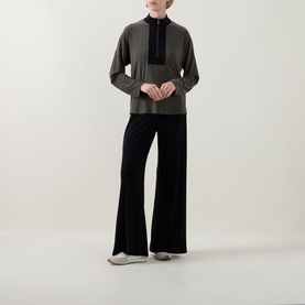 Model wearing Joseph Ribkoff Black/Avocado wide-leg trousers with matching half-zip top and grey trainers.