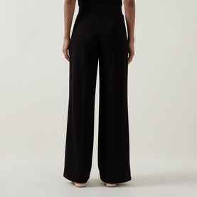 Model wearing Joseph Ribkoff Wide Leg Scuba Trousers in black, shown from behind, with wide-leg silhouette and elasticated waist.