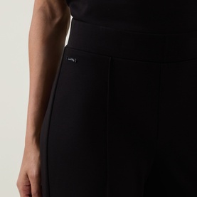 Model wearing Joseph Ribkoff Wide Leg Scuba Trousers in black, showing elasticated waist and pleated front detail at hip.