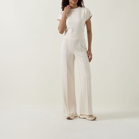 Model wearing Joseph Ribkoff Wide Leg Scuba Trousers in Birch, styled with matching top and white trainers. Pleated front, pull-on design.
