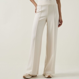 Model wearing Joseph Ribkoff Wide Leg Scuba Trousers in Birch, pleated front, styled with cream knit top and beige loafers