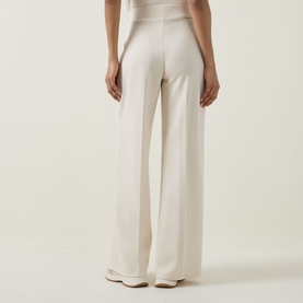 Model wearing Joseph Ribkoff Wide Leg Scuba Trousers in Birch, back view showing wide-leg silhouette and elasticated waist, styled with a cream top.