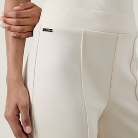 Model wearing Joseph Ribkoff Wide Leg Scuba Trousers in Birch, showing pleated front detail and elasticated waistband with label tab.