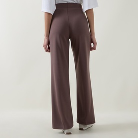 Model wearing Joseph Ribkoff mink wide-leg trousers, rear view, styled with a white top and silver heels.