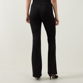 Model wearing Joseph Ribkoff Velour Flared-Leg Trousers in black, showing rear view with flared hem, styled with black heels