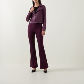 Model wearing Joseph Ribkoff Elderberry flared trousers, styled with a matching purple leather biker jacket and black heels.