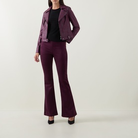 Model wearing Joseph Ribkoff Elderberry flared trousers, styled with a matching purple biker jacket and black heels.