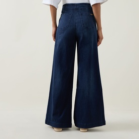 Model wearing Joseph Ribkoff dark denim blue wide-leg trousers, rear view, styled with a white top.