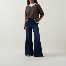 Model wearing Joseph Ribkoff dark denim blue wide-leg flared trousers, styled with a brown V-neck knit and white tee.