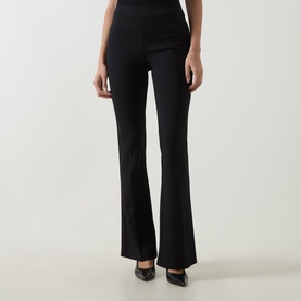 Model wearing Joseph Ribkoff black flared trousers, styled with black pointed-toe heels