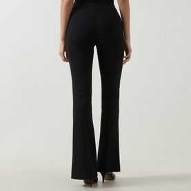Model wearing Joseph Ribkoff black flared trousers, rear view, styled with brown heeled mules. High-waisted fit with smooth finish.