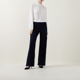 Model wearing Joseph Ribkoff dark denim blue wide-leg trousers with white blouse and black heels.