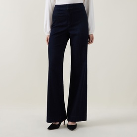 Model wearing Joseph Ribkoff dark denim blue wide-leg trousers, styled with a white top and black heels.