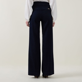 Model wearing Joseph Ribkoff dark denim blue wide-leg trousers, rear view, styled with a white blouse. High-waisted with clean silhouette.