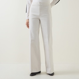 Model wearing Joseph Ribkoff High-Rise Wide Leg Jeans in Birch, featuring pressed creases and wide leg silhouette, styled with a white top.
