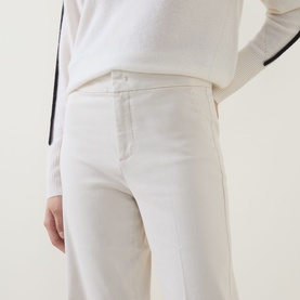 Model wearing Joseph Ribkoff High-Rise Wide Leg Jeans in Birch, styled with a white knit top with black trim detailing.