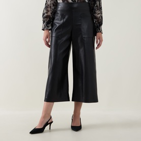 Model wearing Joseph Ribkoff black faux leather wide-leg cropped trousers, styled with a sheer floral blouse and black slingback heels.