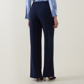 Model wearing Joseph Ribkoff indigo wide-leg trousers, rear view, styled with a light blue blouse and black heels.