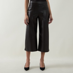 Model wearing Joseph Ribkoff Faux Leather Culottes Trousers in Mocha, wide-leg cropped silhouette with faux leather finish, styled with black heels.