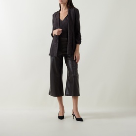 Model wearing Joseph Ribkoff Faux Leather Culottes Trousers in Mocha with wide-cut legs, styled with a dark blazer and black heels.