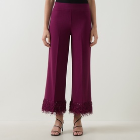 Model wearing Joseph Ribkoff Feather-Trim Cropped Trousers in Berry Burst, wide-leg silhouette with sequin-embellished faux feather cuffs, styled
