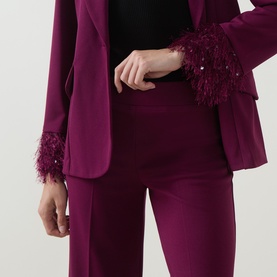 Model wearing Joseph Ribkoff Feather-Trim Cropped Trousers in Berry Burst with sequin-embellished faux feather cuffs, styled with matching berry