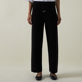 Model wearing Joseph Ribkoff black wide-leg trousers with elasticated drawstring waist, styled with black ballet flats