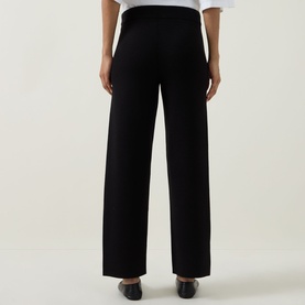 Model wearing Joseph Ribkoff black wide-leg trousers, rear view, styled with a white top and black heels.