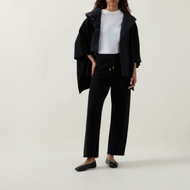 Model wearing Joseph Ribkoff black wide-leg trousers with drawstring waist, styled with black oversized coat and white tee.